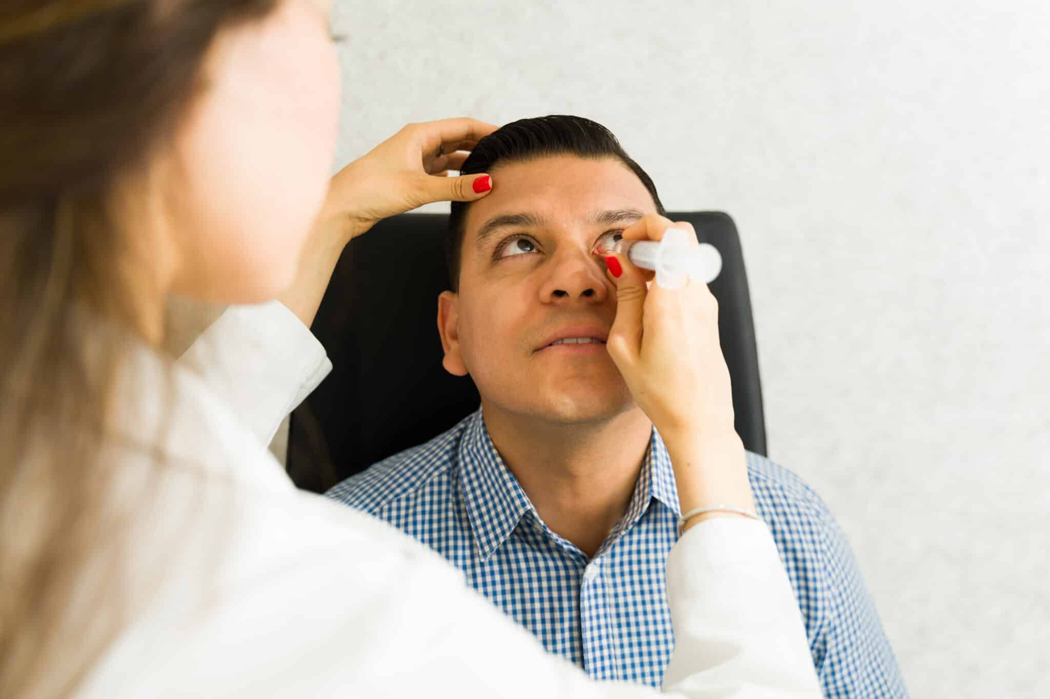 Ophthalmologist using a syringe to remove a tear duct obstruction on a patient