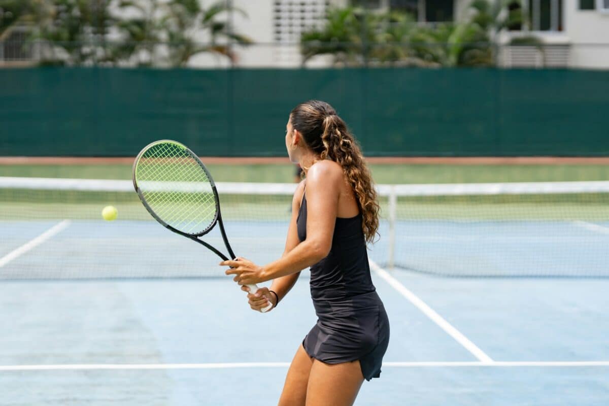 Woman returns a serve in a tennis match