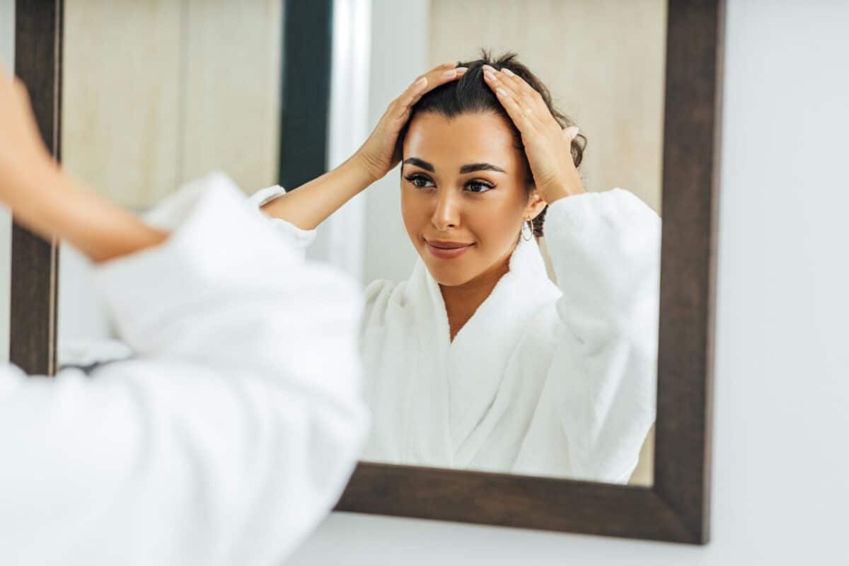 Woman looks at herself in the bathroom mirror