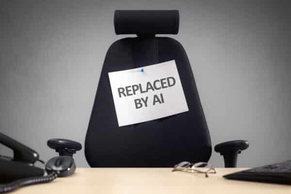 Empty office chair with 'Replaced by AI' sign on it