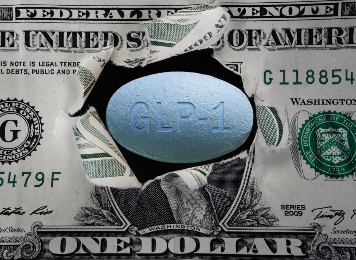 GLP-1 pill in a torn dollar bill
