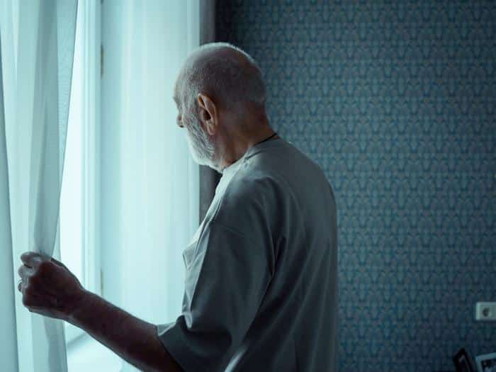 Older Man Looking Out Window