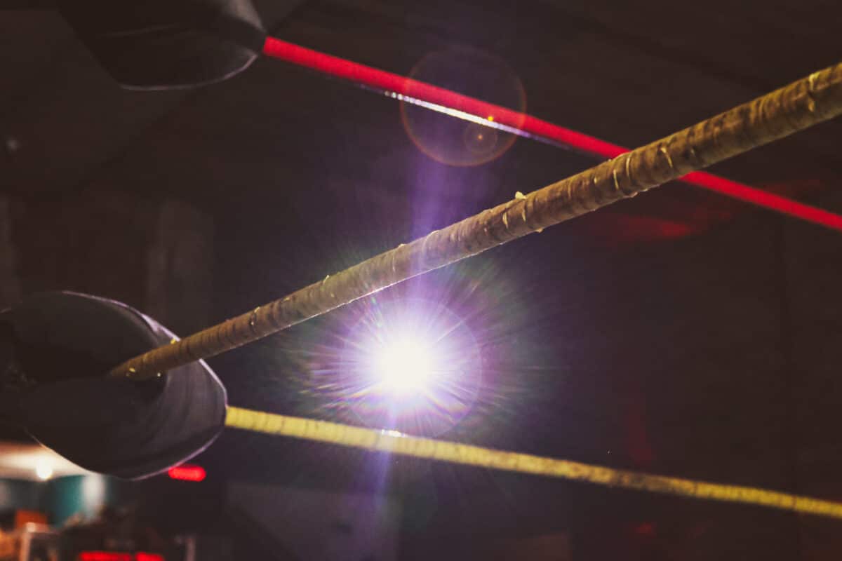 Ropes of a pro wrestling ring highlighted by spotlight
