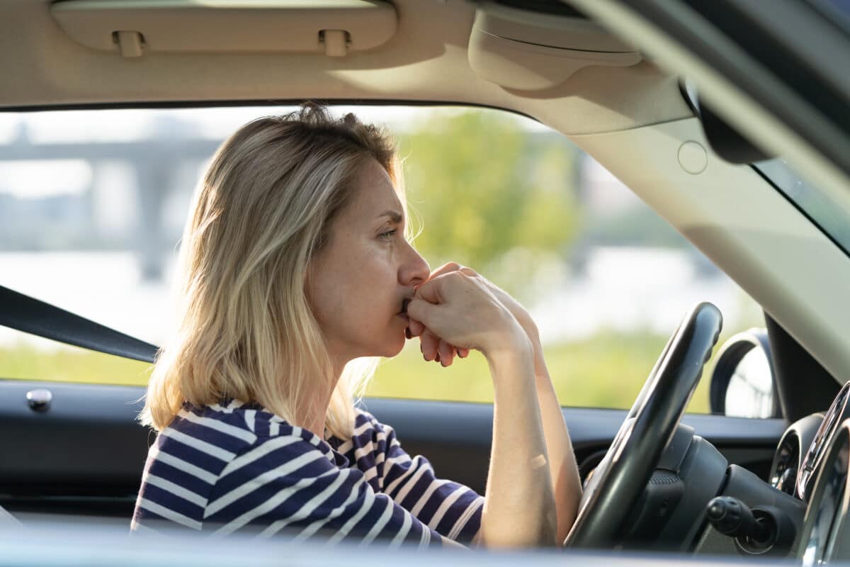 Woman stressed from driving car, perhaps sitting in traffic or lost