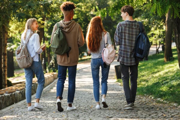 Back view group of teens walking with backpacks