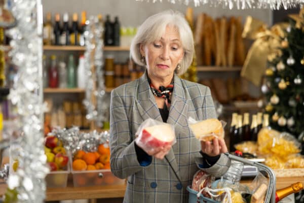 Older woman buying cheese at the grocery store