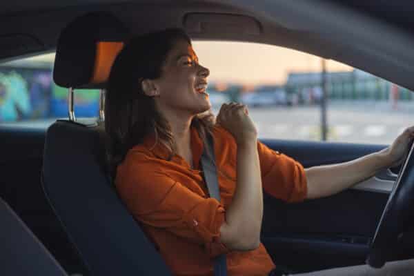 Woman singing in the car while driving